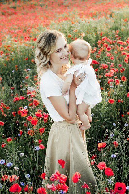 Une femme tient son bébé et sourit