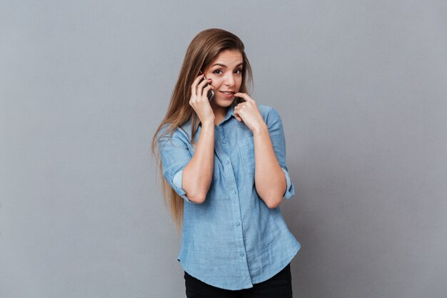 Femme timide en chemise, parler au téléphone