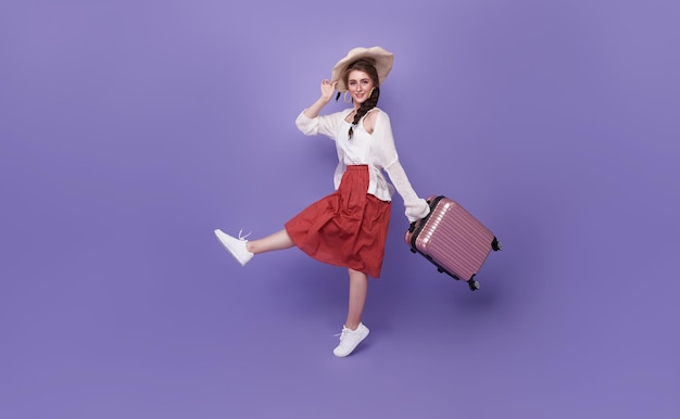 Photo gratuite femme de tourisme joyeuse voyageur en vêtements d'été chapeau sautant en cours d'exécution tenir la valise