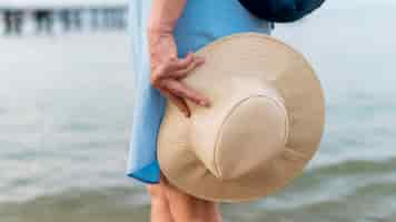 Photo gratuite femme de tourisme senior tenant un chapeau de plage