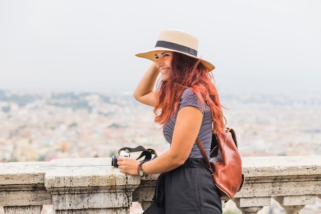 Femme touriste avec caméra sur balcon