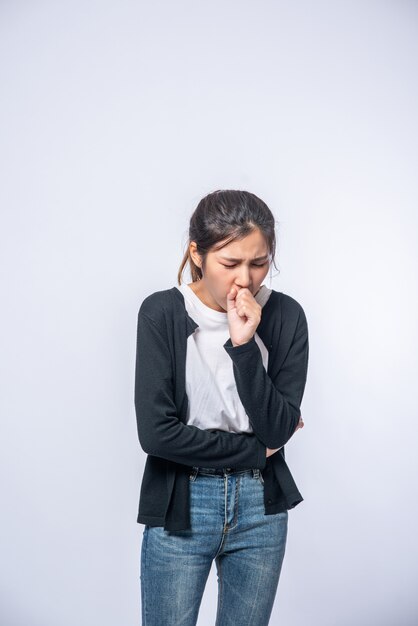 Une femme toussant et couvrant sa bouche avec sa main