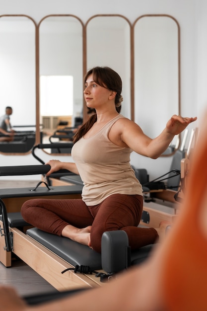 Photo gratuite une femme en train de suivre un cours de pilates.