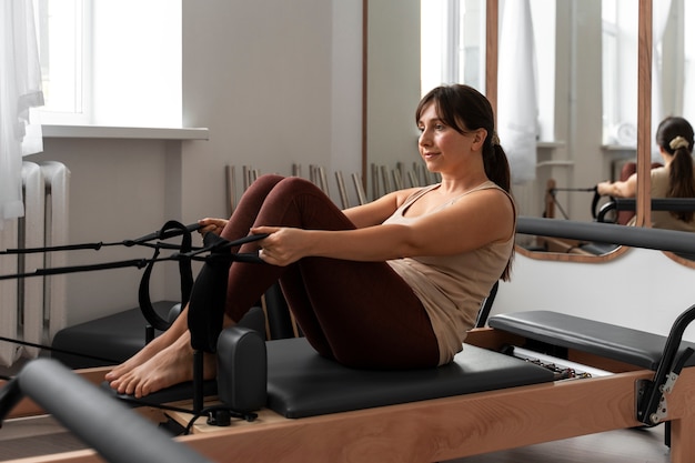 Photo gratuite une femme en train de suivre un cours de pilates.