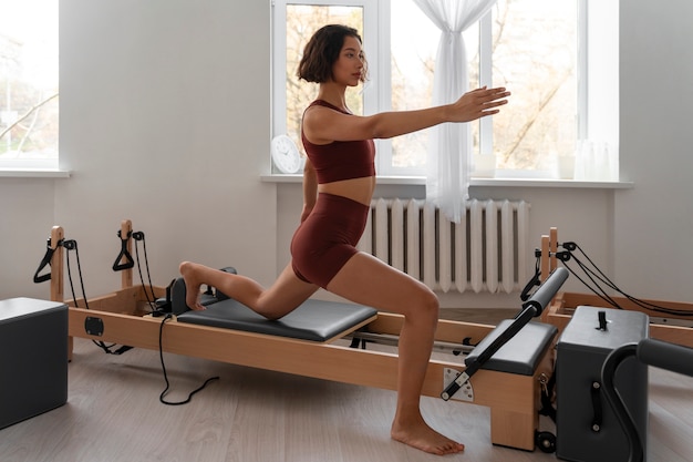 Photo gratuite une femme en train de suivre un cours de pilates.