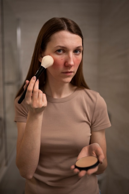 Photo gratuite femme traitant de la rosacée se maquiller avec une brosse