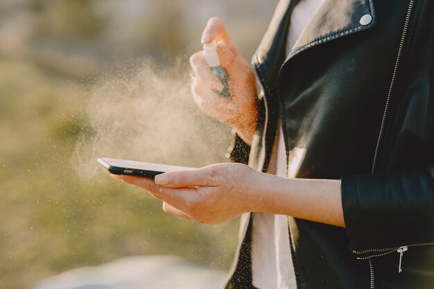 Femme traite son téléphone avec un antiseptique