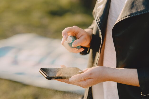 Femme traite son téléphone avec un antiseptique