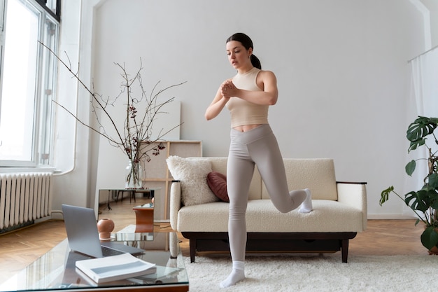 Femme travaillant après un instructeur de fitness en ligne