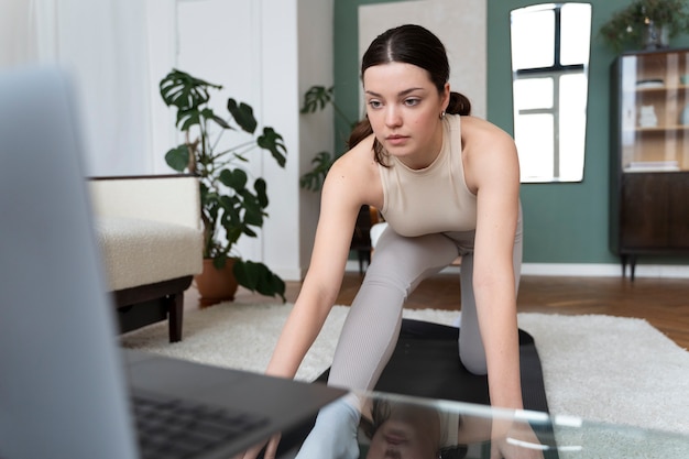 Femme travaillant après un instructeur de fitness en ligne