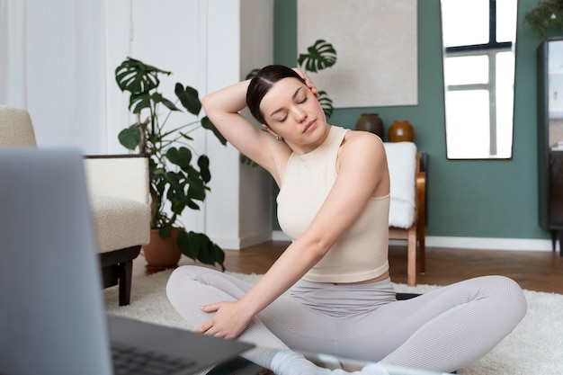 Femme travaillant après un instructeur de fitness en ligne