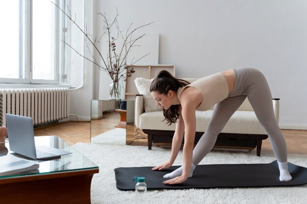 Femme travaillant après un instructeur de fitness en ligne