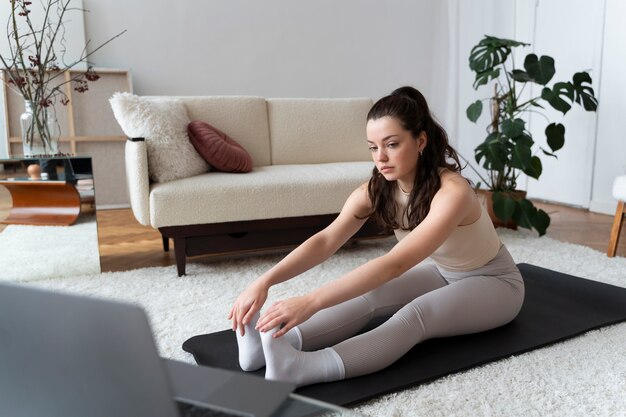 Femme travaillant après un instructeur de fitness en ligne