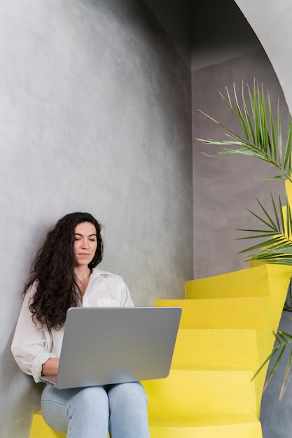 Femme travaillant et assise dans les escaliers