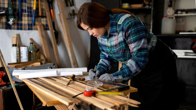 Femme travaillant en atelier avec ruban à mesurer