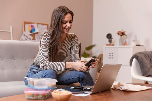 Femme travaillant et ayant des boîtes à lunch à côté d'elle