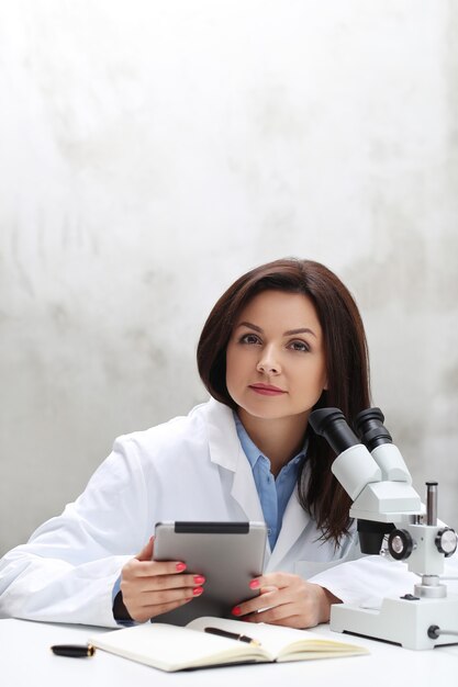 Femme travaillant dans le laboratoire avec un microscope