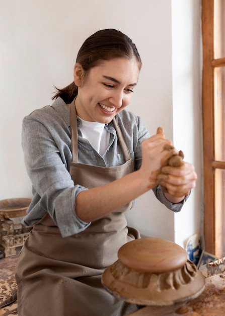 Photo gratuite femme travaillant dans un lieu de travail de poterie