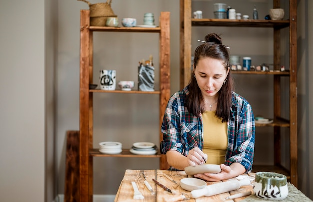 Femme travaillant dans son atelier de poterie