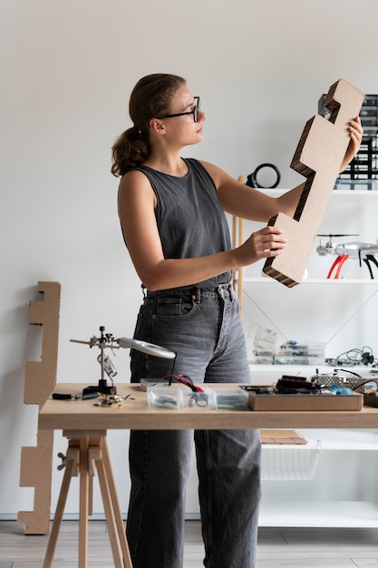 Photo gratuite femme travaillant dans son atelier pour une invention créative