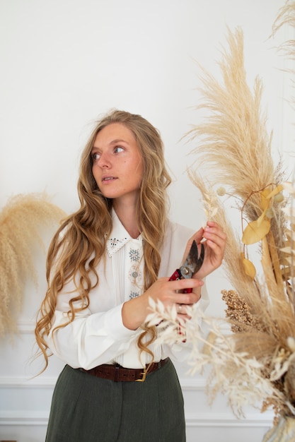 Femme travaillant avec des fleurs séchées coup moyen