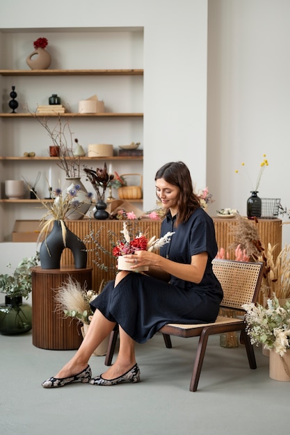 Femme travaillant avec des fleurs séchées