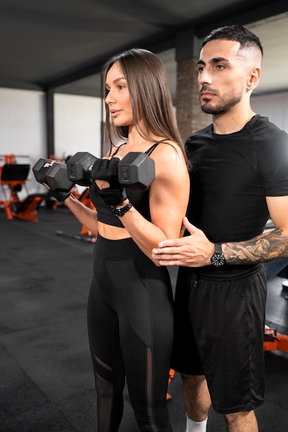 Femme travaillant avec des haltères coup moyen