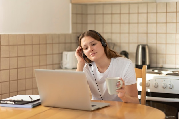 Femme travaillant à la maison dans la cuisine pendant la quarantaine