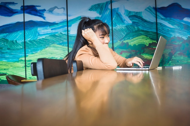 Femme travaillant à l&#39;ordinateur portable à la table