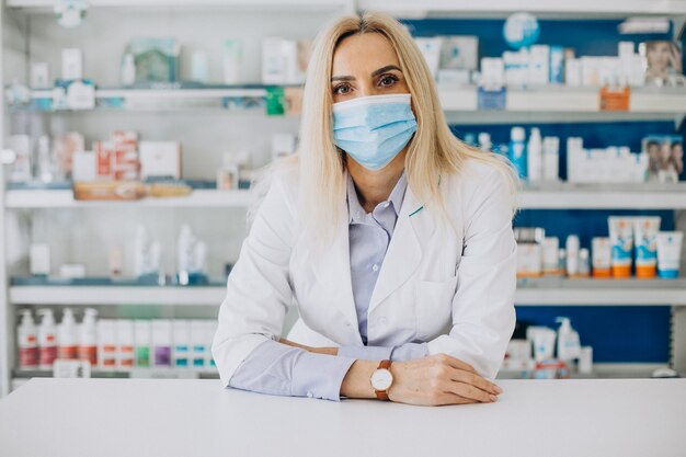 Femme travaillant à la pharmacie et portant un manteau