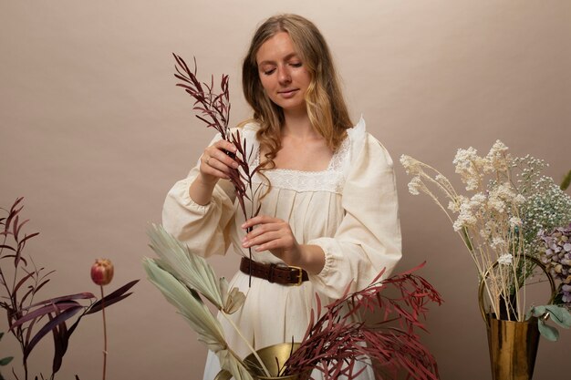 Photo gratuite femme travaillant avec des plantes séchées vue de face