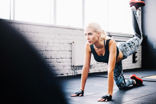 Photo gratuite femme travaillant sur le sol de la salle de gym