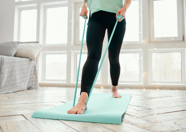 Femme travaillant sur tapis avec bande élastique