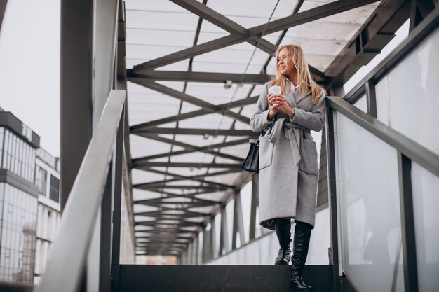 Femme traversant le pont et boire du café