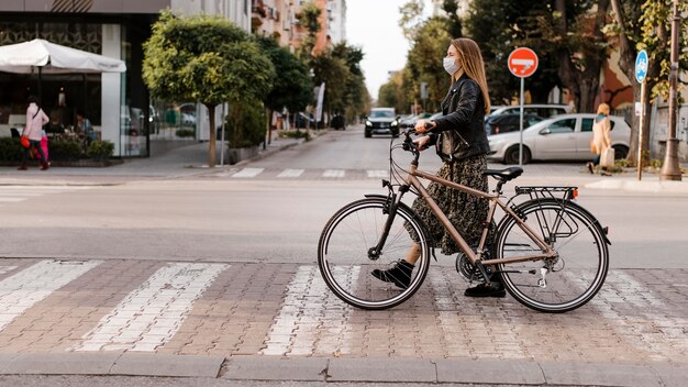 Femme traversant la rue à côté de son vélo