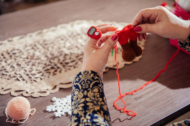 Photo gratuite femme tricotant des chiffres avec du fil rouge