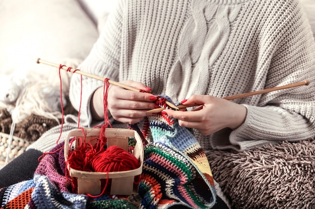 Photo gratuite femme tricote des aiguilles à tricoter sur le canapé