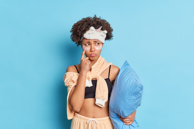 Une femme triste déçue montre des coussinets de collagène sous les yeux se sent malheureuse d'aller au lit