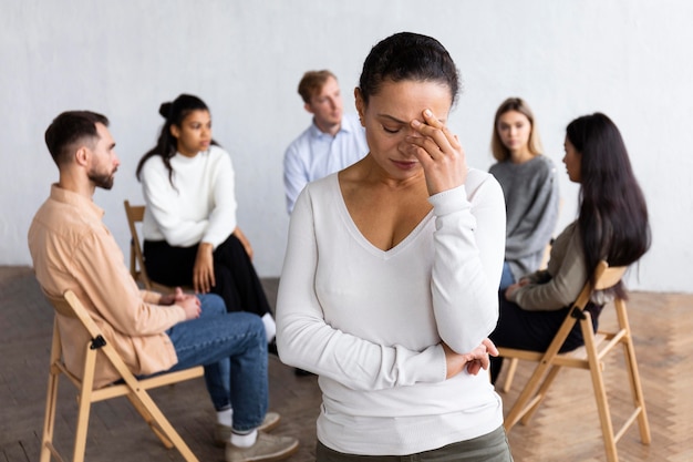 Femme triste lors d'une séance de thérapie de groupe