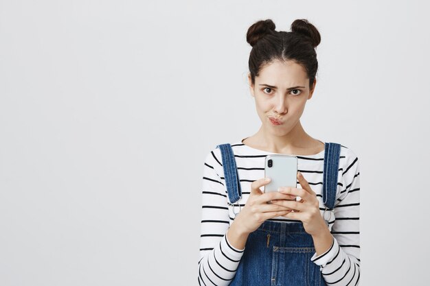 Femme troublée pensant, utilisant un téléphone mobile