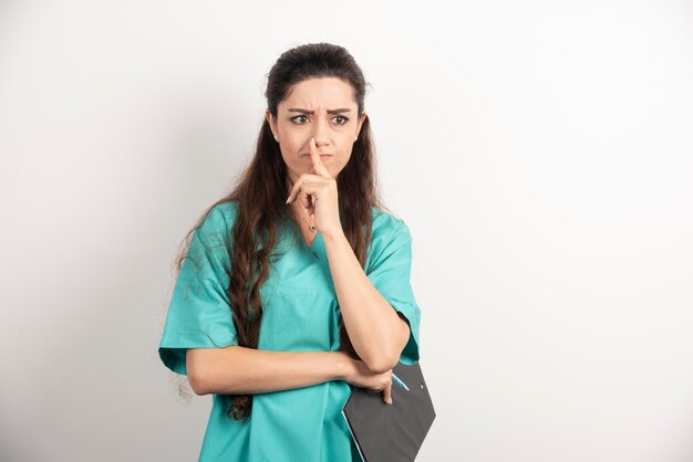 Femme en uniforme de médecin tenant le presse-papiers