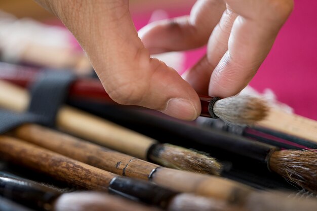 Femme utilisant des brosses spéciales pour l'art japonais