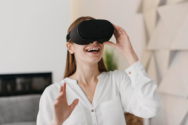 Femme utilisant un casque de réalité virtuelle et sourit