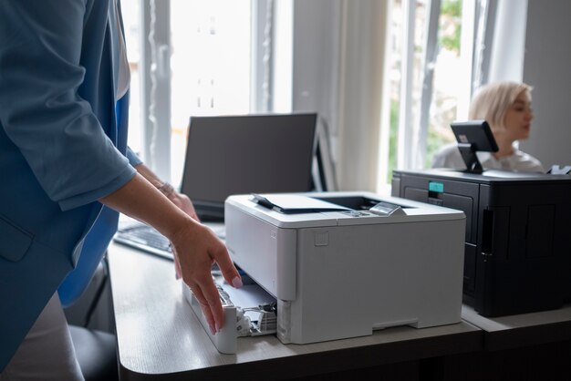 Femme utilisant une imprimante au bureau au travail