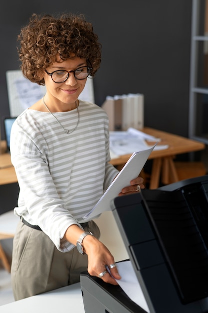 Femme utilisant une imprimante au travail à angle élevé