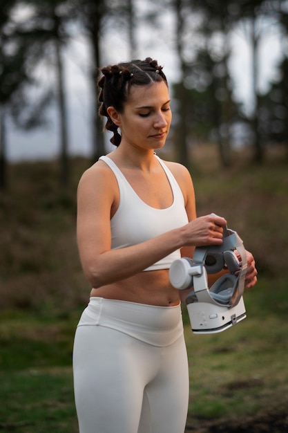 Photo gratuite femme utilisant des lunettes vr pour faire de l'exercice à l'extérieur dans la nature