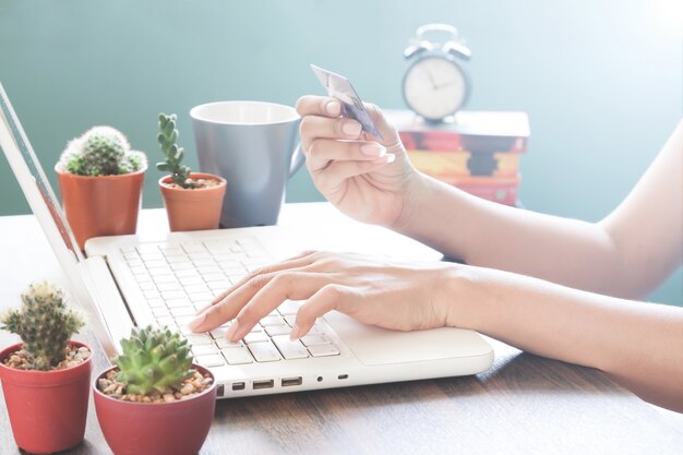 Femme utilisant un ordinateur portable et tenant une carte de crédit, Achats en ligne