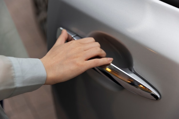 Femme utilisant la porte de sa voiture électrique