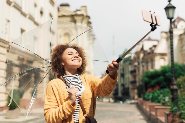 Femme utilisant son bâton de selfie pour prendre une photo
