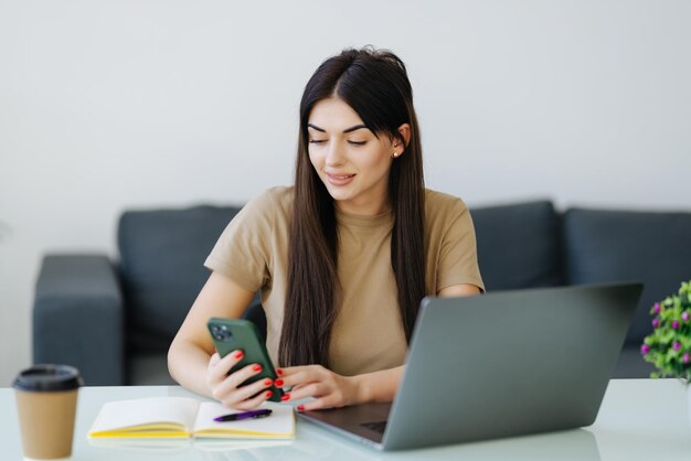 Femme utilisant son téléphone portable travaillant à domicile